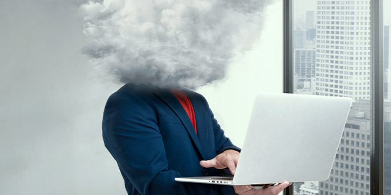 Pourquoi les PME et ETI misent sur l’infogérance pour garder leur performance en période d’incertitude économique ? Un employé d'une PME sur son ordinateur qui a la tête dans le brouillard