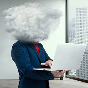 Un employé d'une PME sur son ordinateur qui a la tête dans le brouillard