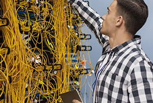 Un jeune ingénieur réseau travaillant dans une salle de serveur
