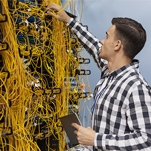 Un jeune ingénieur réseau travaillant dans une salle de serveur