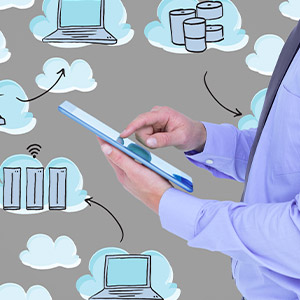 Gros plan sur les mains d'un homme en costume qui utilise une tablette, avec des icônes représentant le cloud qui gravitent autour.